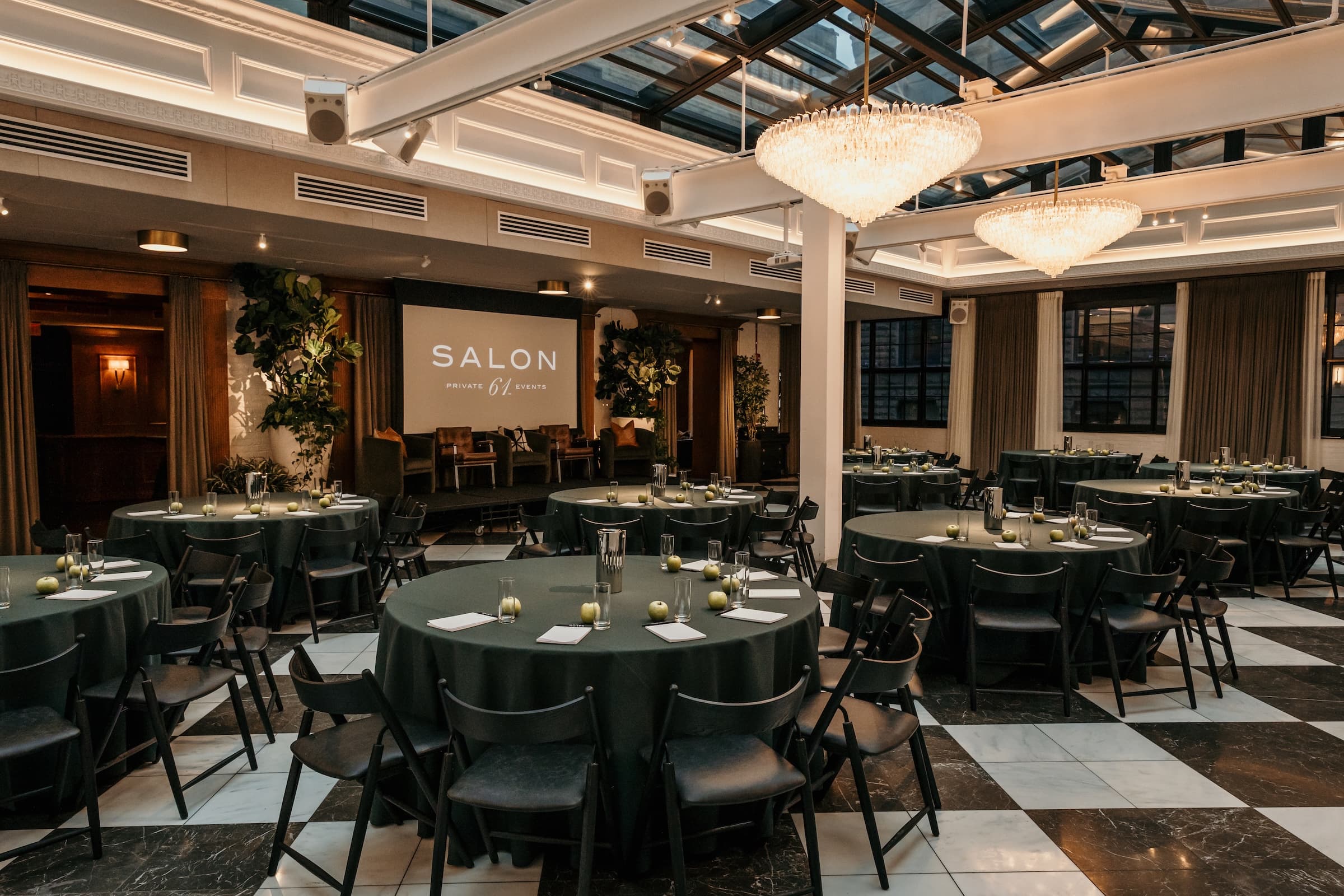 Meeting/conference style set up with chairs in rows in an theater-style arch facing a platform stage.