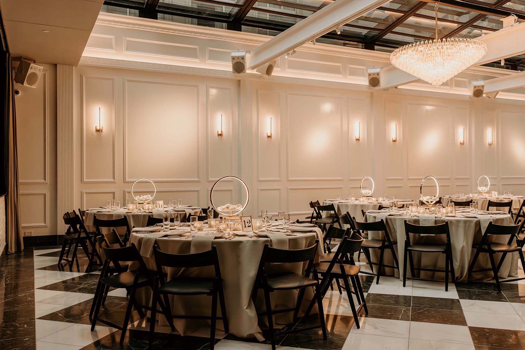 Atrium with soft lighting and tables set with cream colored linens